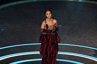 Zoe Saldaña accepts the award for Best Supporting Actress at the 2025 Oscars.