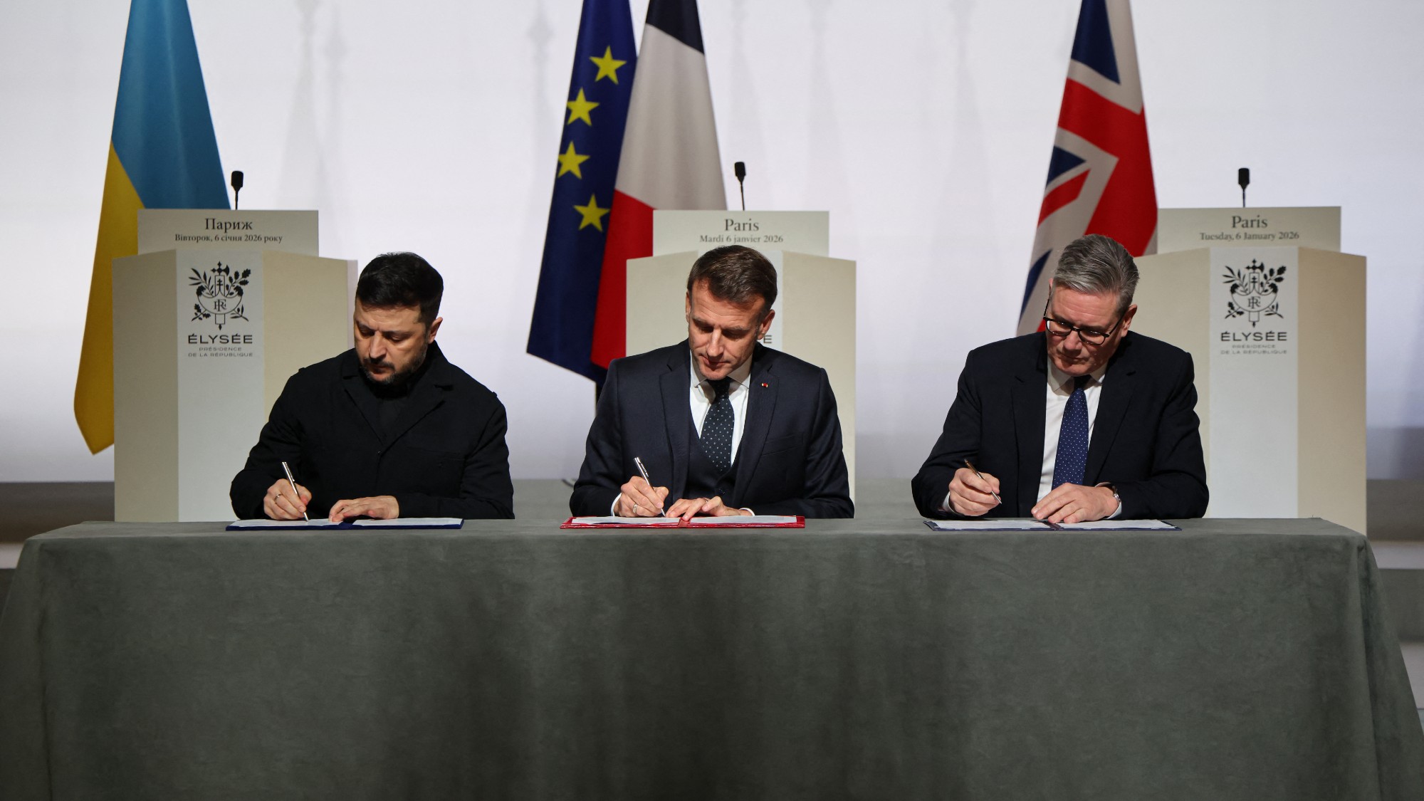 Ukraine's President Volodymyr Zelensky, France's President Emmanuel Macron and Britain's Prime Minister Keir Starmer sign the declaration on deploying post-ceasefire force in Ukraine during the Coalition of the Willing summit
