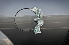 five and one dollar bills sticking out of a gray car flap