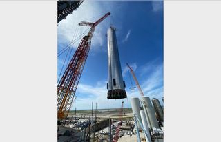 SpaceX lifts the Super Heavy known as Booster 4 onto the launch stand at its South Texas site on Aug. 4, 2021. This photo was posted on Twitter that day by SpaceX founder and CEO Elon Musk.