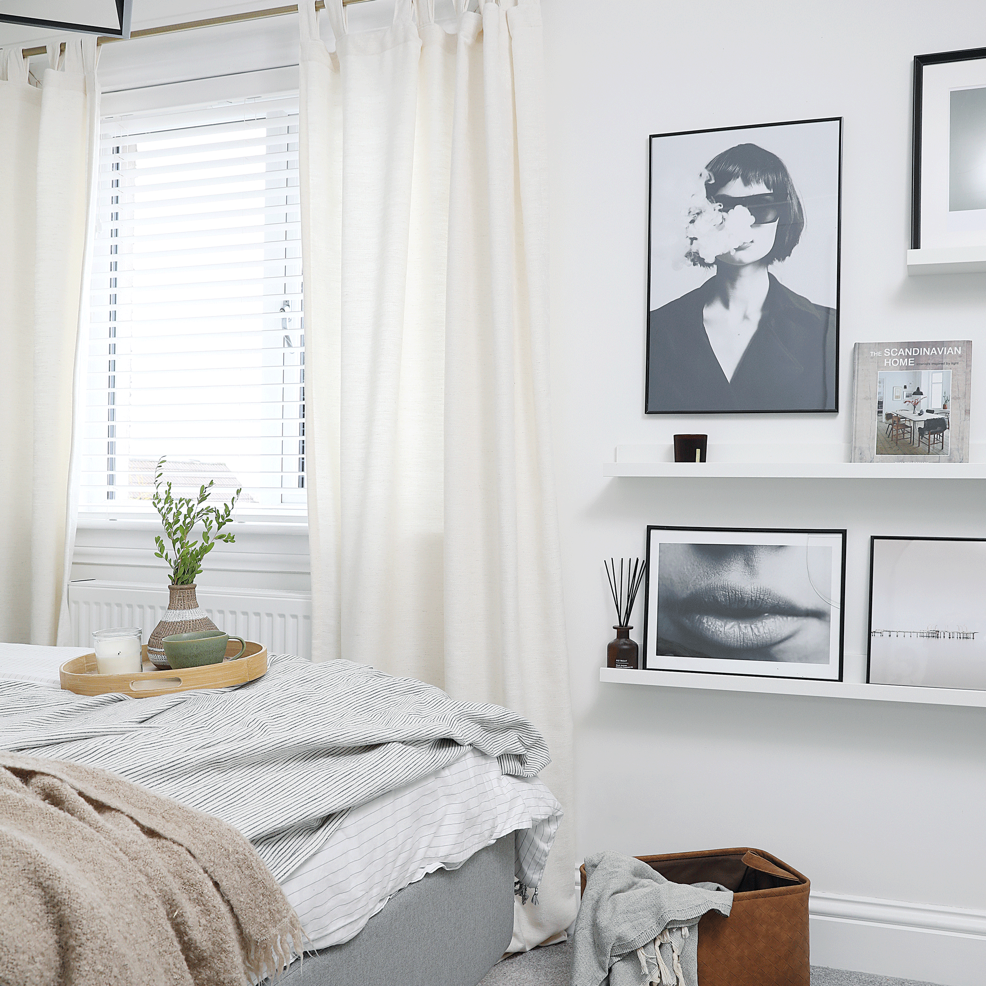 a neutral bedroom with a gallery wall of black and white photo art