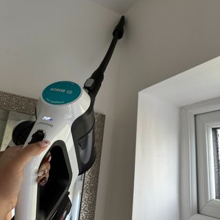 Using the long crevice tool on the Bosch Unlimited 7 Aqua cordless vacuum and mop during the testing process