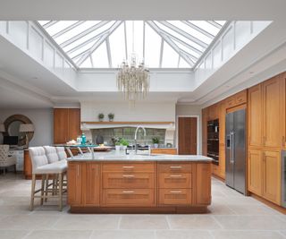 second hand kitchen in natural wood panelling with large central island in new extension