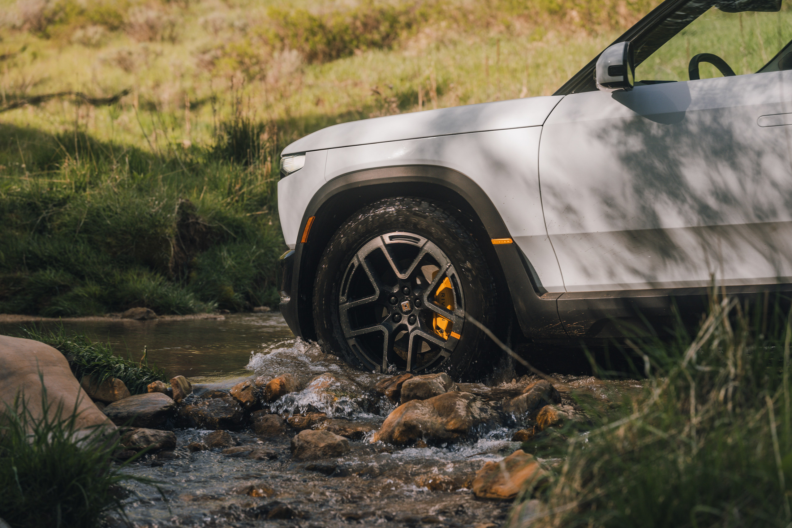 Rivian R2 fording a stream