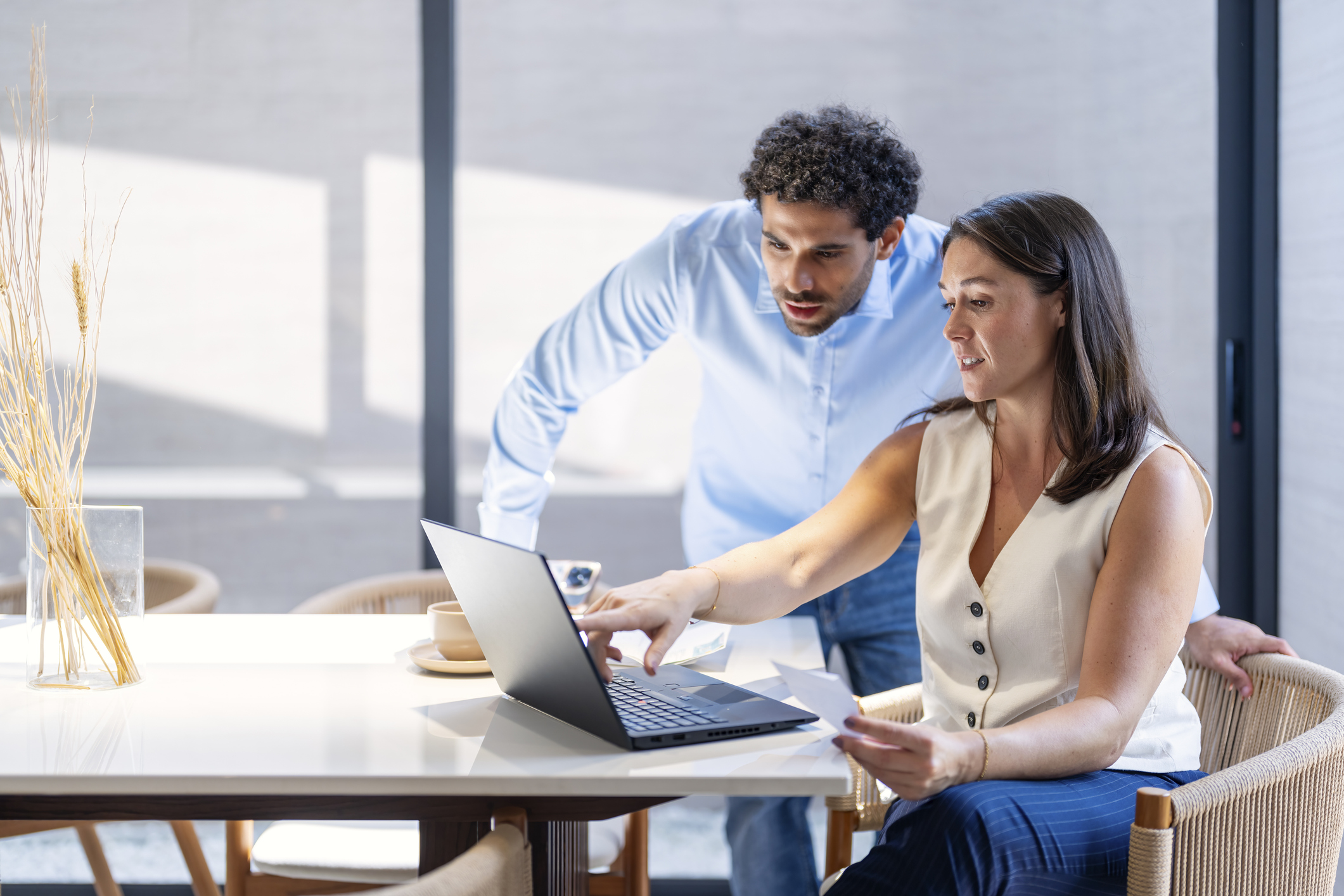 Young Couple is going through their household finances, reviewing financial statement paper and doing home accounting with laptop computer.