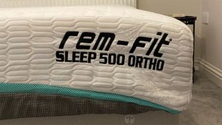 Close up of the corner of the REM-Fit 500 Ortho Hybrid mattress on a bed