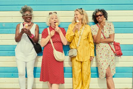 Four mature women eating ice cream cones.