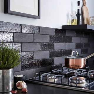 black and grey tile wall stove and black shelf