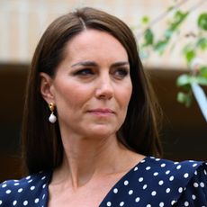Kate Middleton with a steely expression in a blue polka dot dress