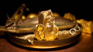 A large gold nugget on copper scales.