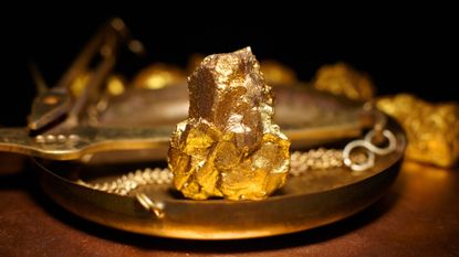 A large gold nugget on copper scales.