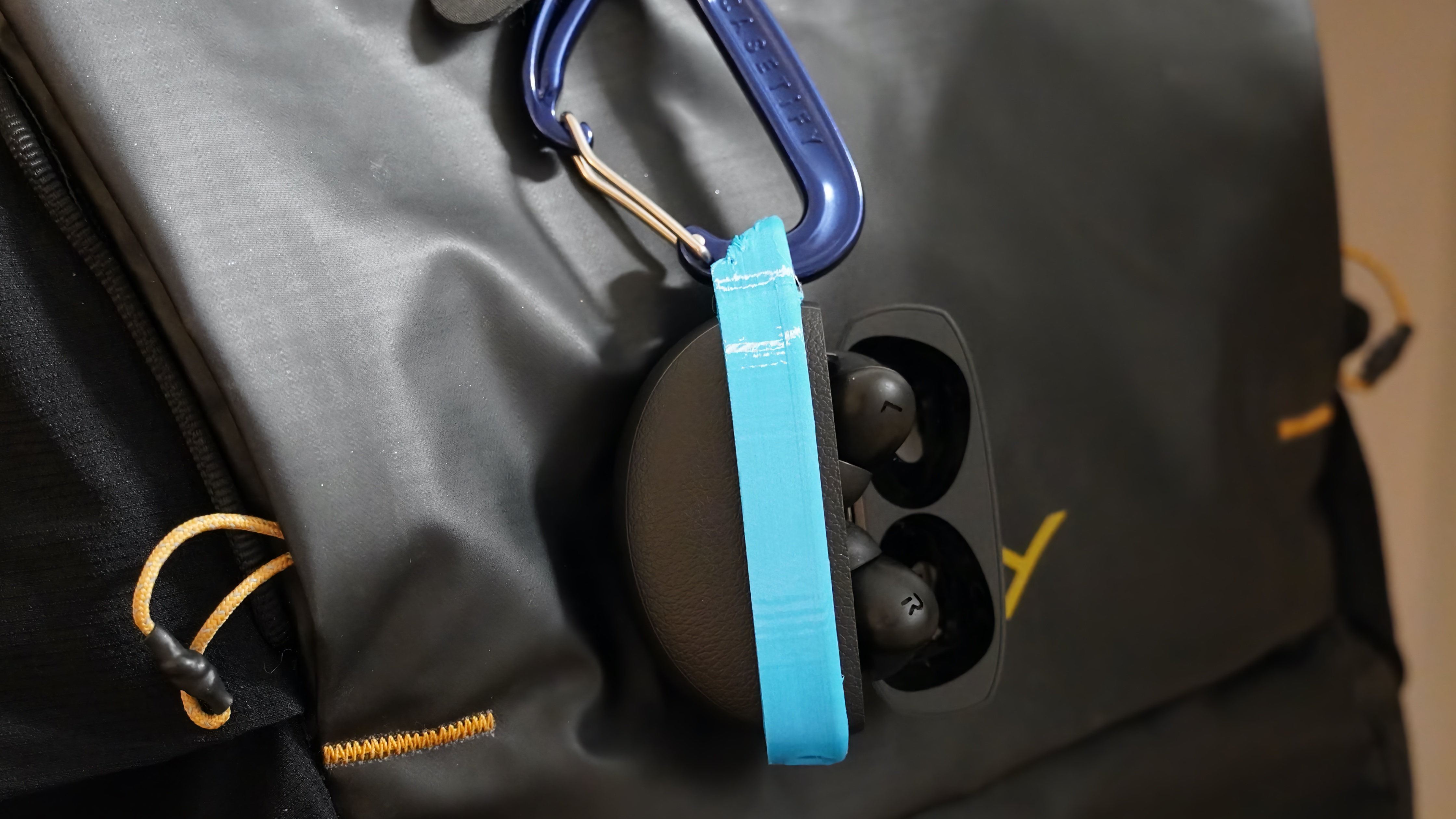 The OnePlus Buds Pro 3 hanging from a bag with a 3D-printed case.