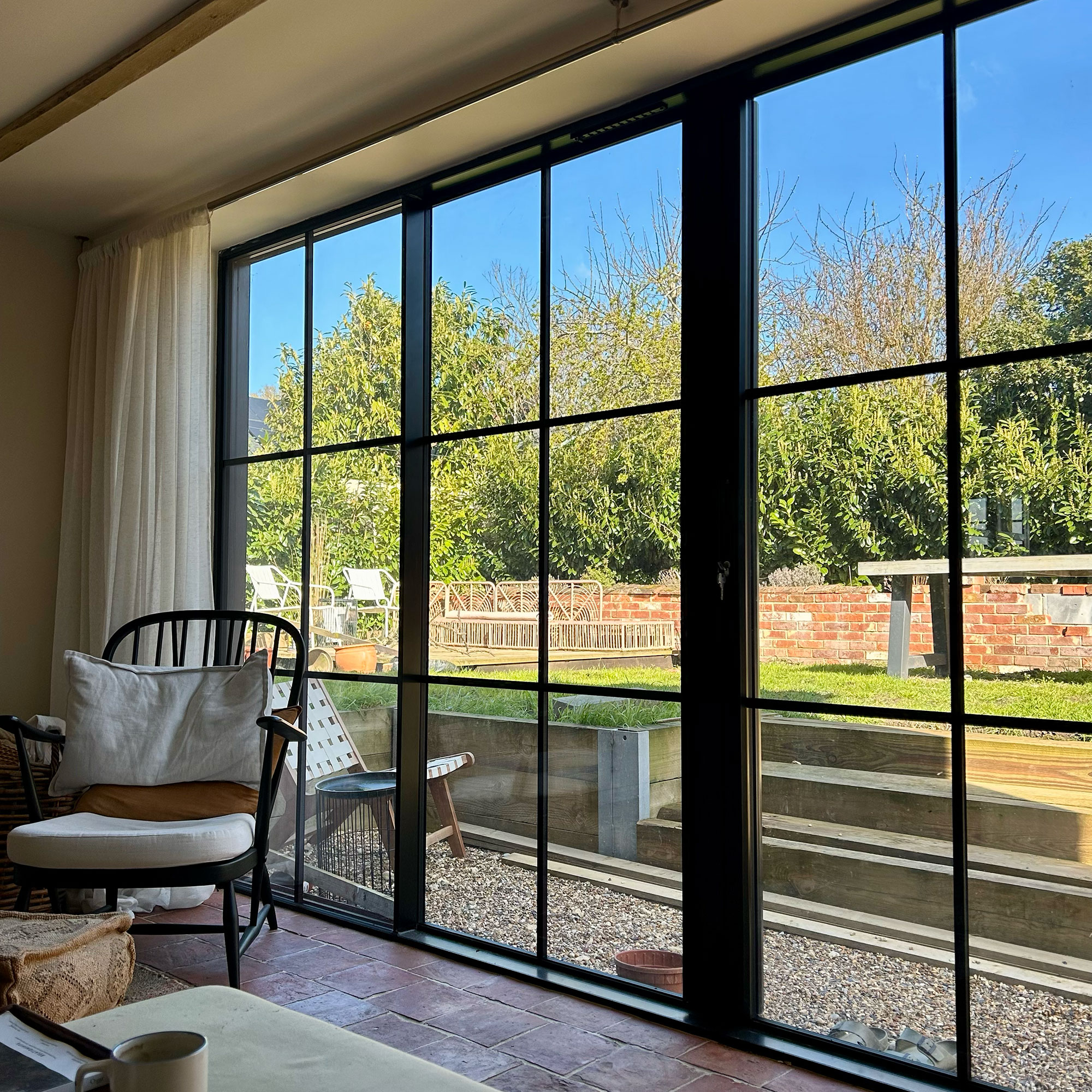 Double crittal style doors leading from inside to garden space