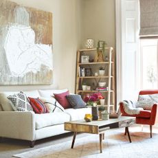 living area with carpets flooring and art work and ladder shelves and sofa and arm chairs