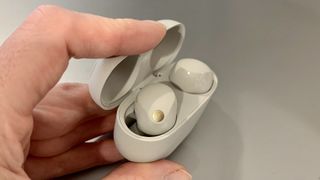 Les écouteurs Sony WF-1000XM5 et l'étui dans la main