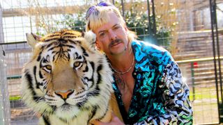 Joe Exotic of "Tiger King" poses with a tiger.