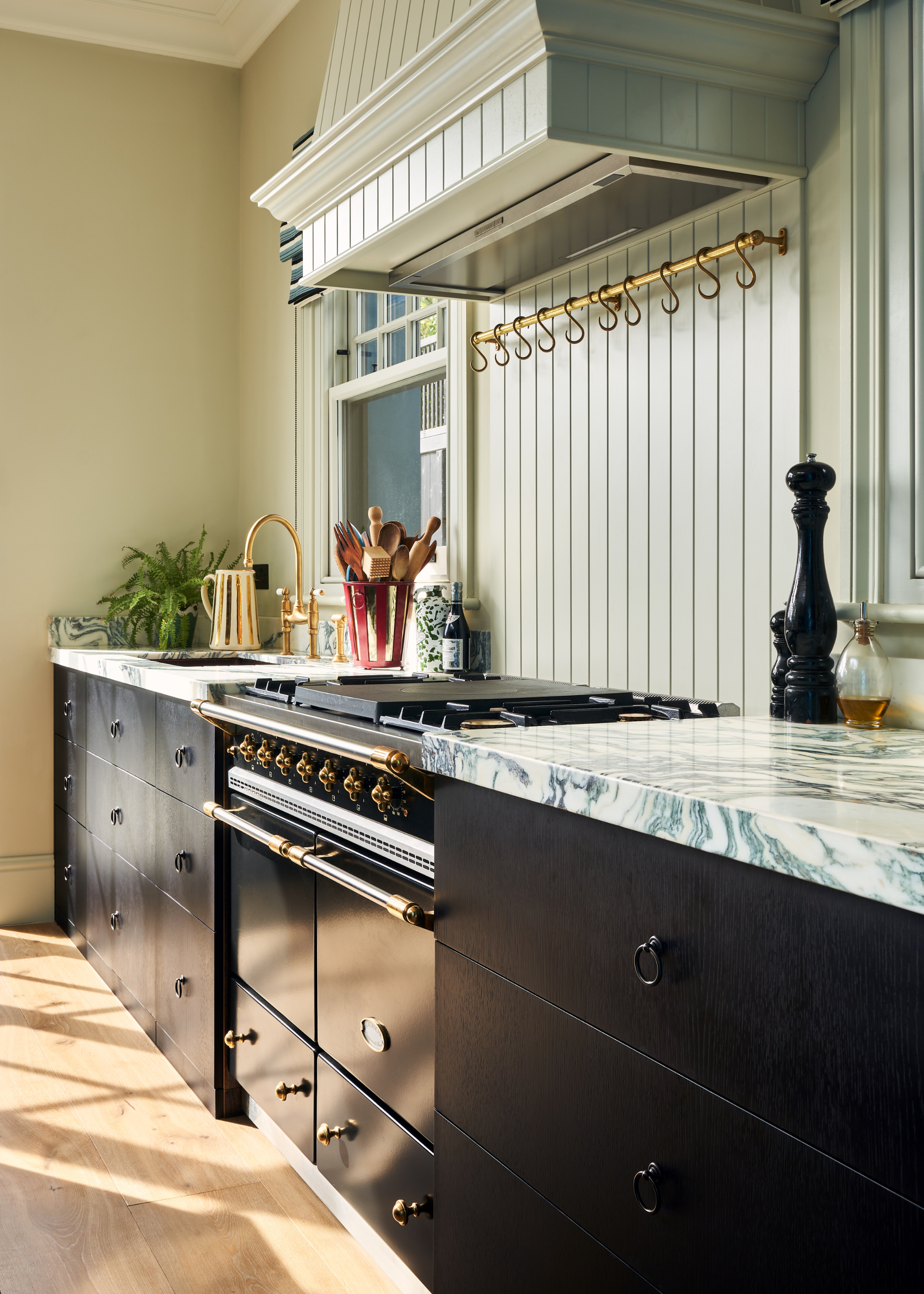 range cooker in black in a kitchen with marble counters and black cabinets