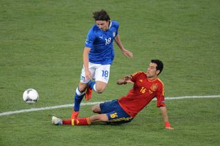 Spain's Sergio Busquets slides in to intercept the ball ahead of Italy's Riccardo Montolivo in the Euro 2012 final.