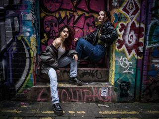Hasselblad 907X & CFV 100C sample image – street portrait of two young people in leather jackets, posing in a graffiti-covered doorway
