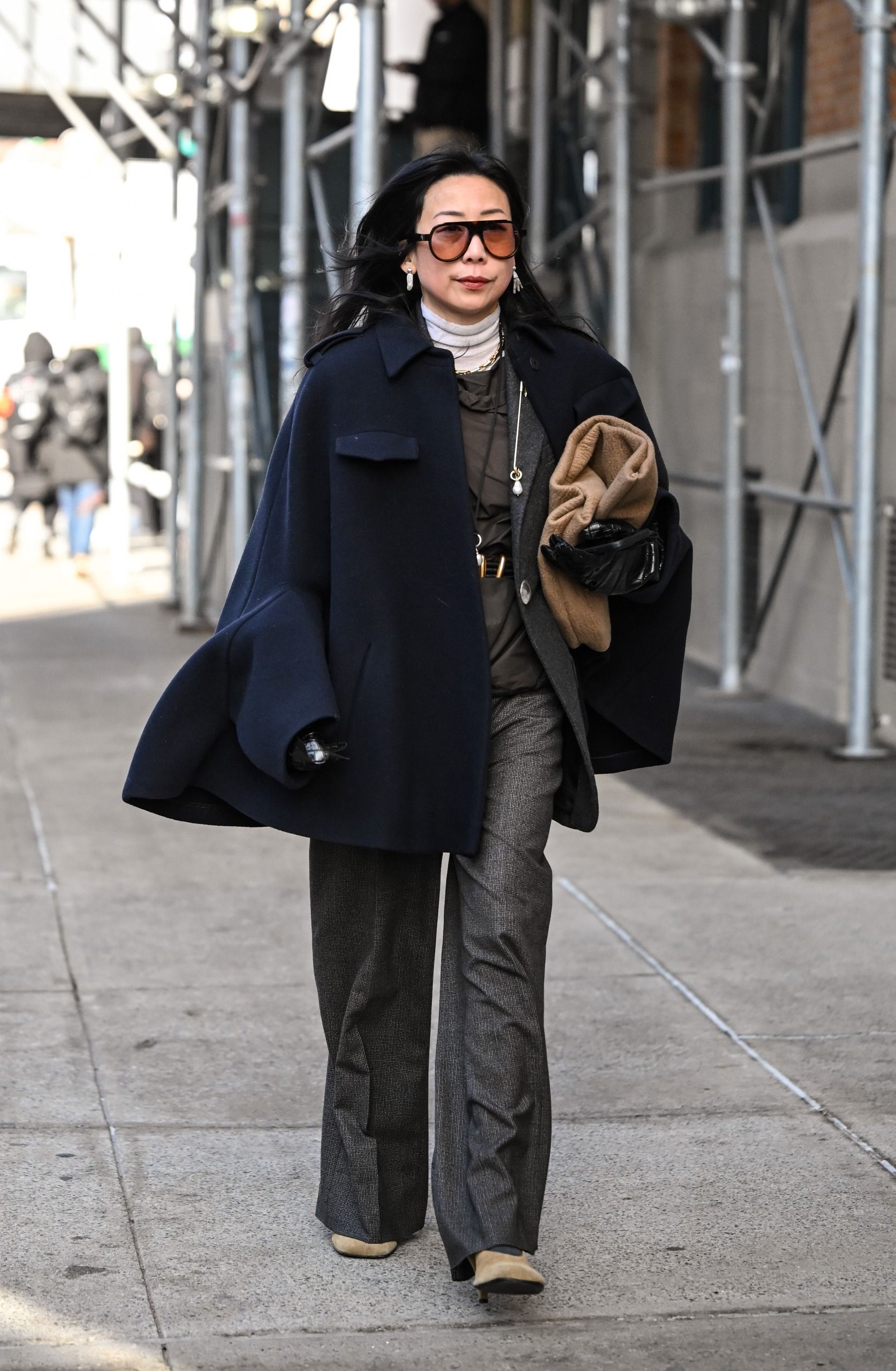 woman wearing navy cape coat street style