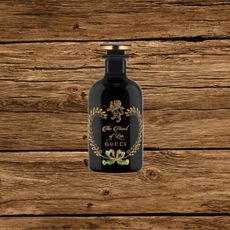 A black bottle of Gucci perfume with gold lettering on it