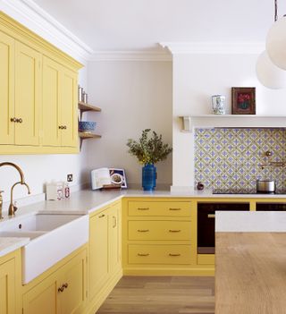 A kitchen with bright yellow cabinets