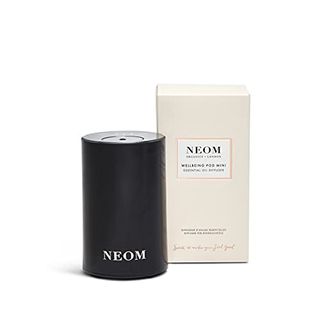 A small portable oil diffuser with a pink box behind it. Neom branding