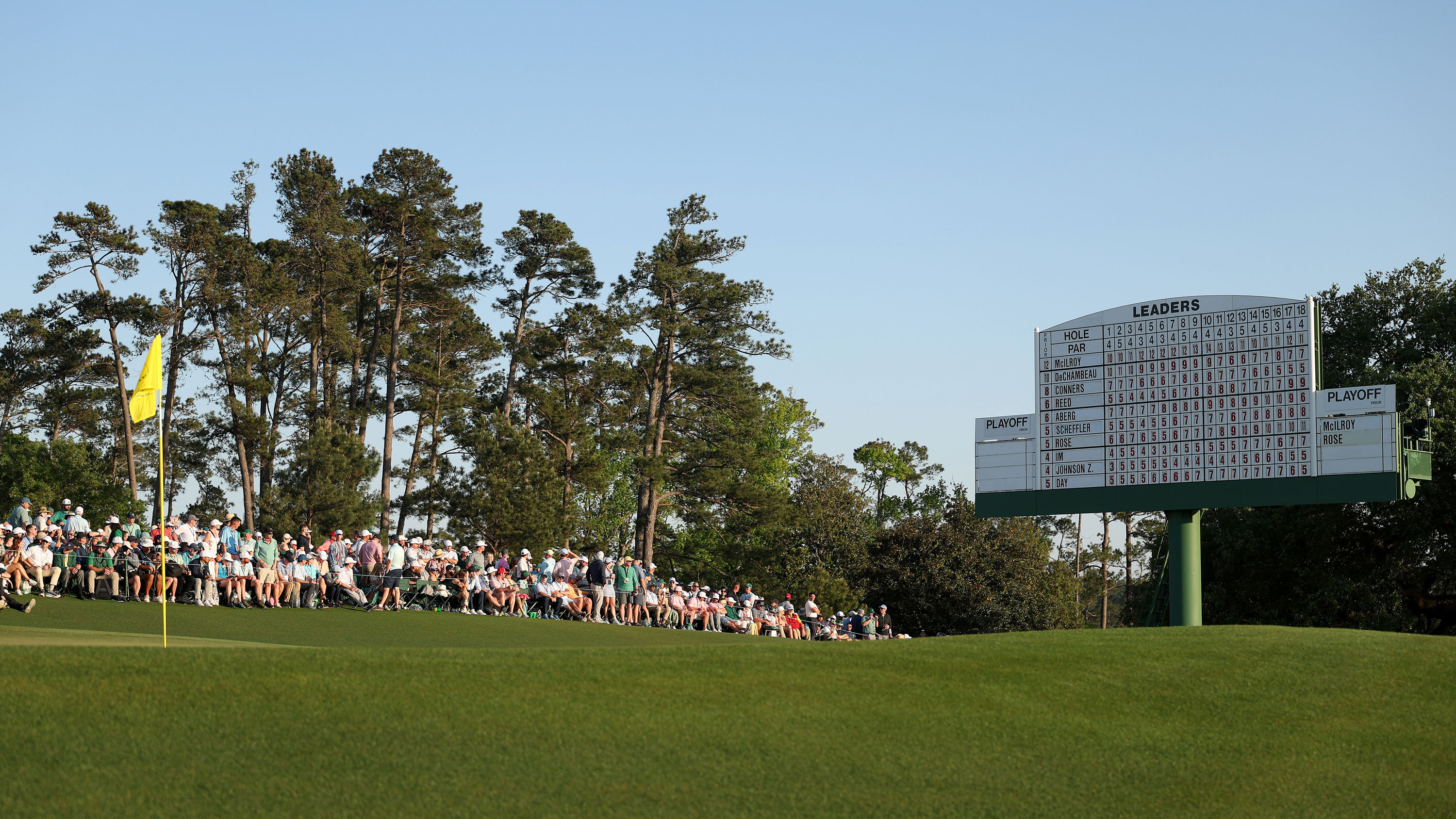 the flag on the 18th green at Augusta National with a scoreboard behind