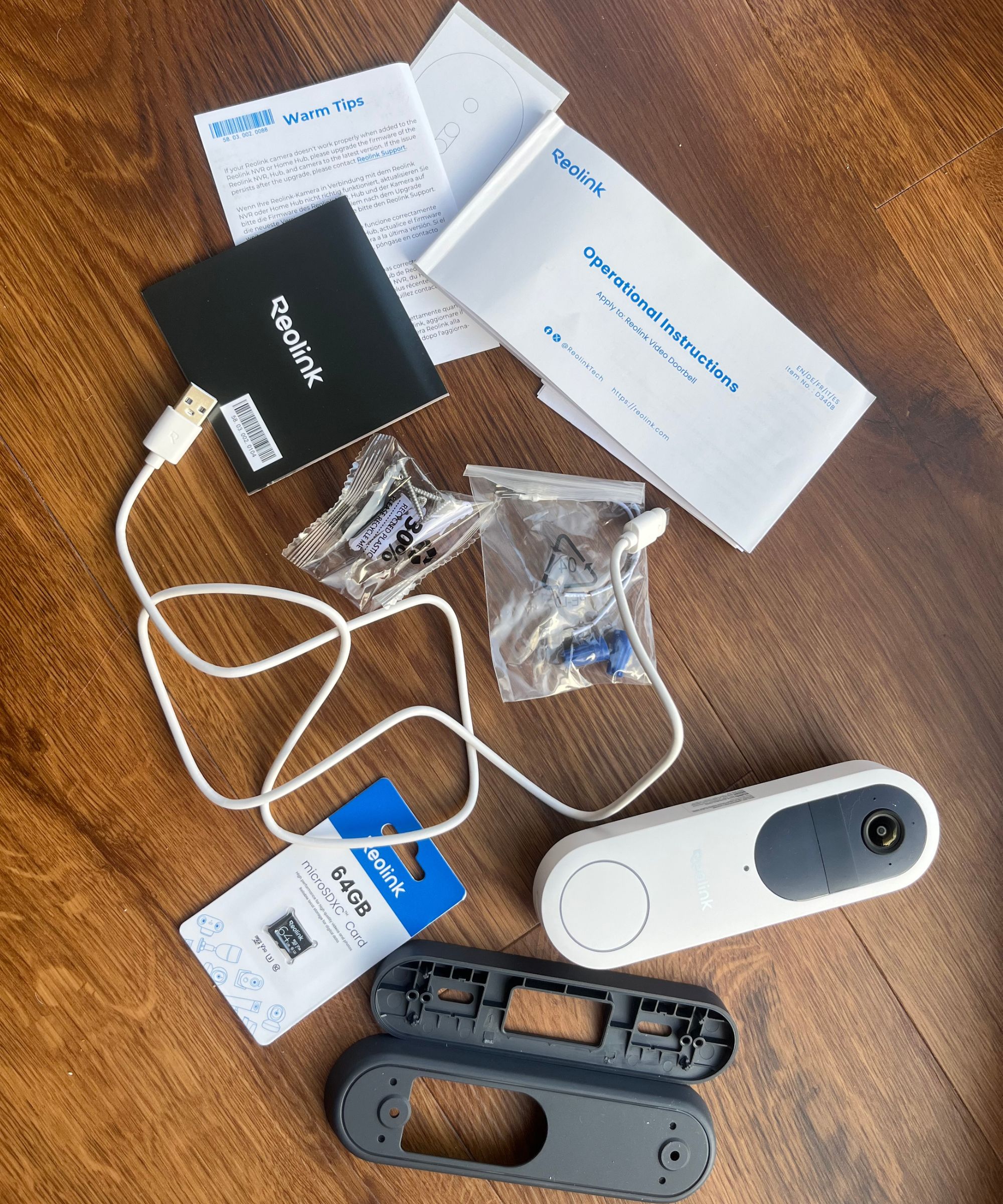 Every part included with the Reolink video doorbell on wooden surface.