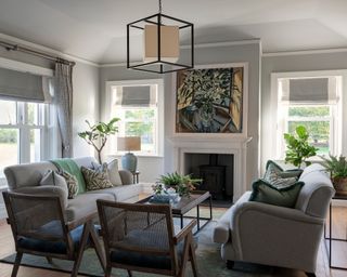 neutral living room with neutral sofas, statement artwork, cane chairs and cube lantern