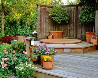 sunken hot tub in decking surrounded by container plants