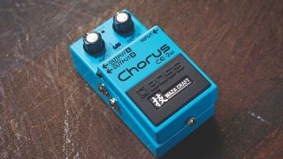 A Boss CE-2W Waza Craft chorus pedal on a scratched wooden floor