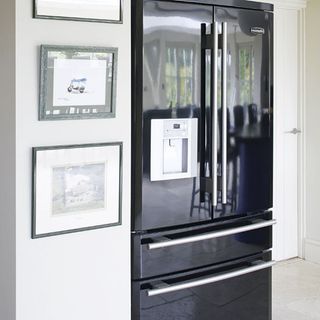kitchen with white wall and double door black fridge