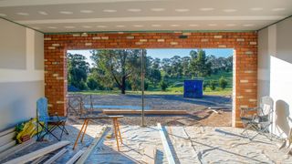 view inside garage conversion in progress of being plasterboarded looking out of entrance towards garden
