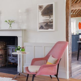 Pink chair in living room next to side table and woodburner