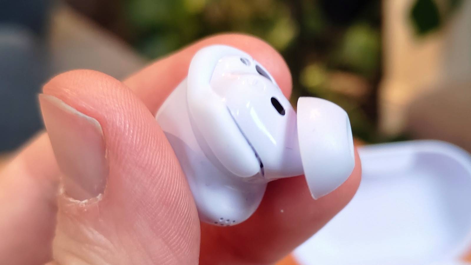 A close up of the Bose QuietComfort Earbuds 2024, held in the hand.