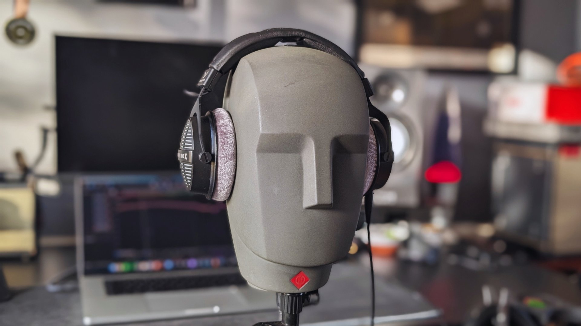 A pair of Beyerdynamic DT 990 Pro X on a Neumann KU 100 dummy head in a home studio