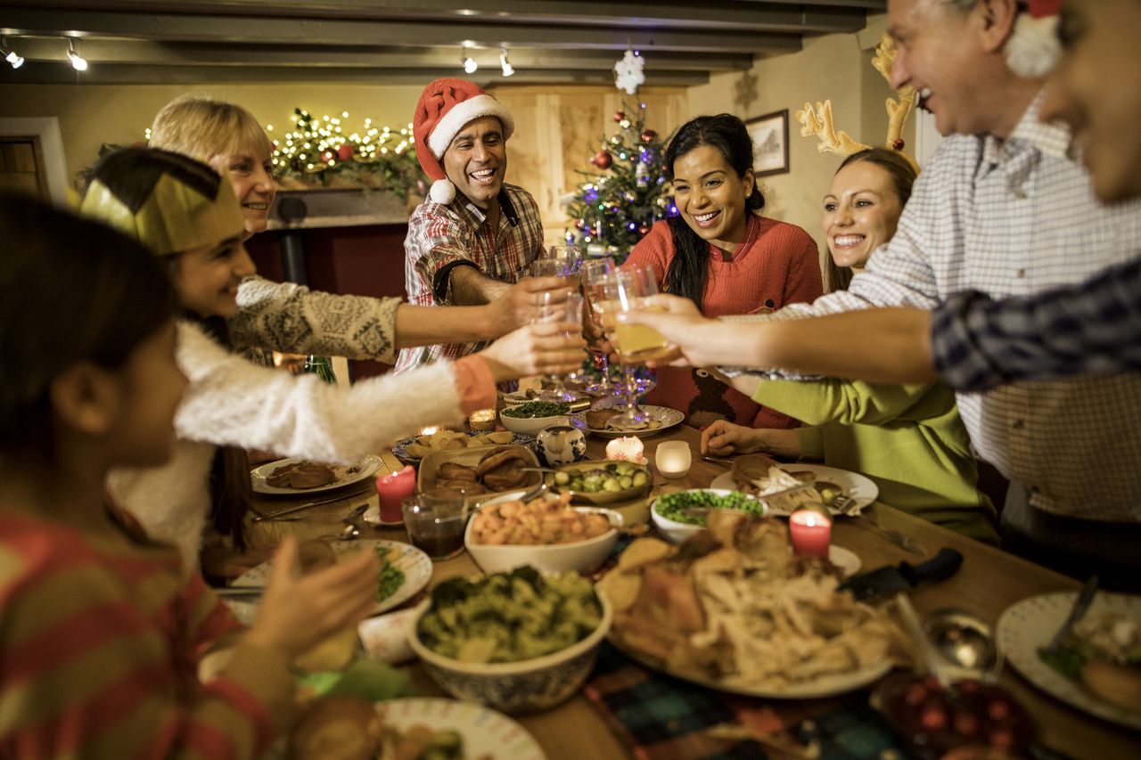 Family gathering around a table of Christmas food