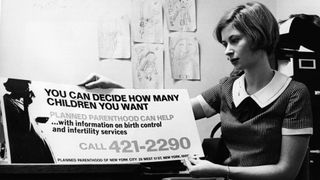 Woman holding Planned Parenthood sign up for review, black and white, 1967