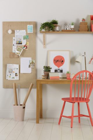 Home office with coral accessories and a large cork board