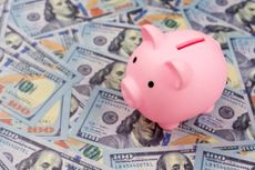 Pink piggy bank with $100 bills