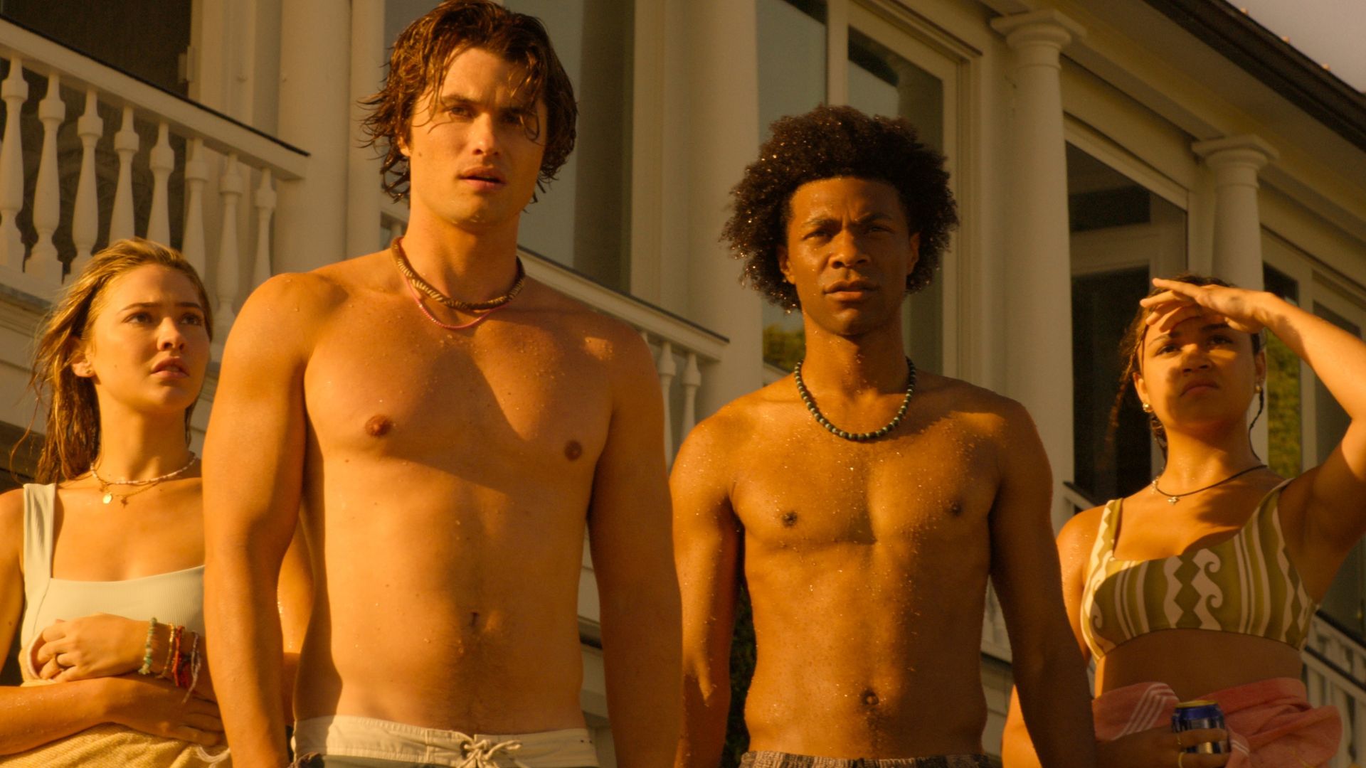 A group of teens stand facing the sun in swimwear
