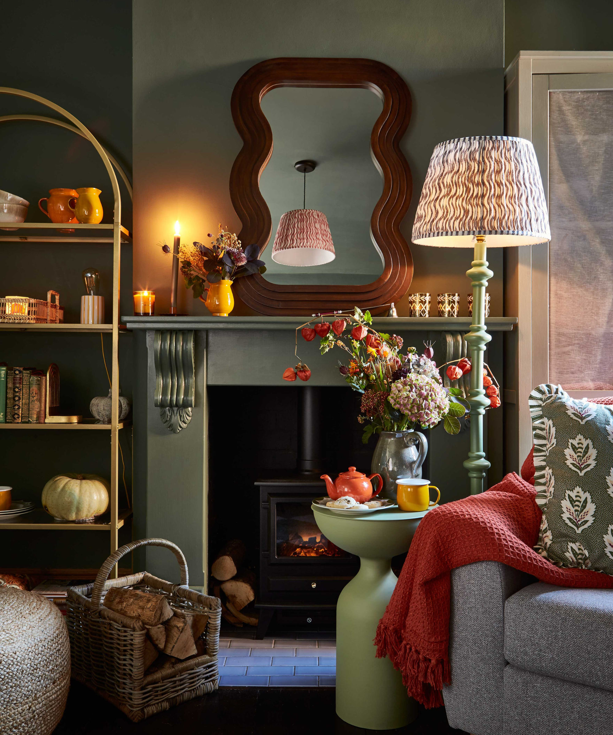 Living room with a chair in the corner, layered lighting, a fireplace with a mirror on it, and a cabinet to the left of fireplace