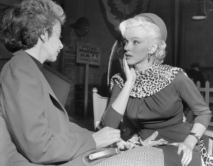 1953: Talking with her acting coach on set