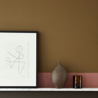 light brown wall with pink detailing and framed minimal black and white artwork