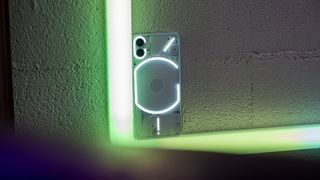 Nothing Phone (1) with its glyph lighting on set against colored lighting