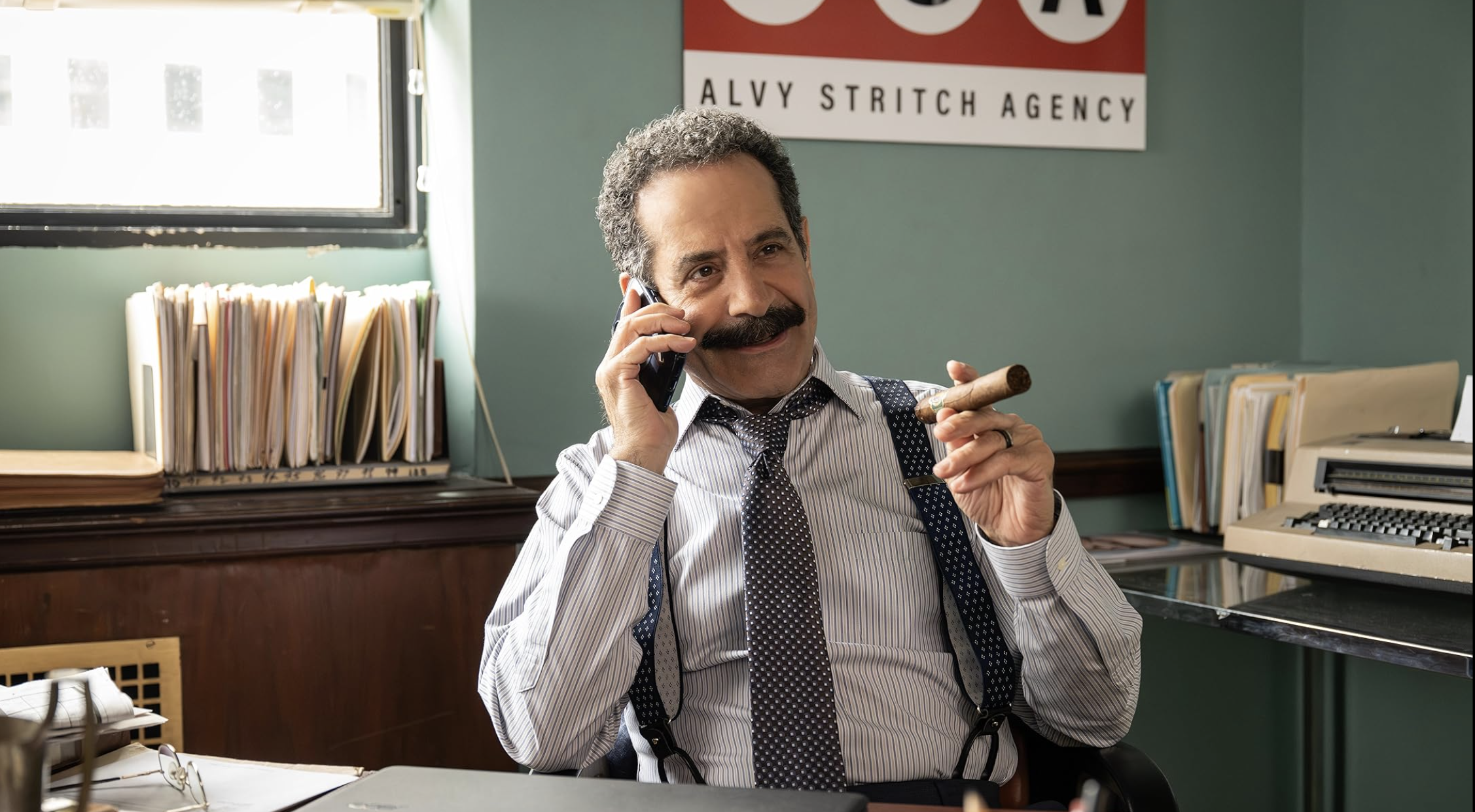 an image still from the show American Classic showing an agent on the phone in his office