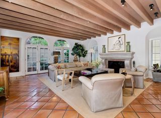 A living room with old style furniture, exposed beams and terracotta tiles