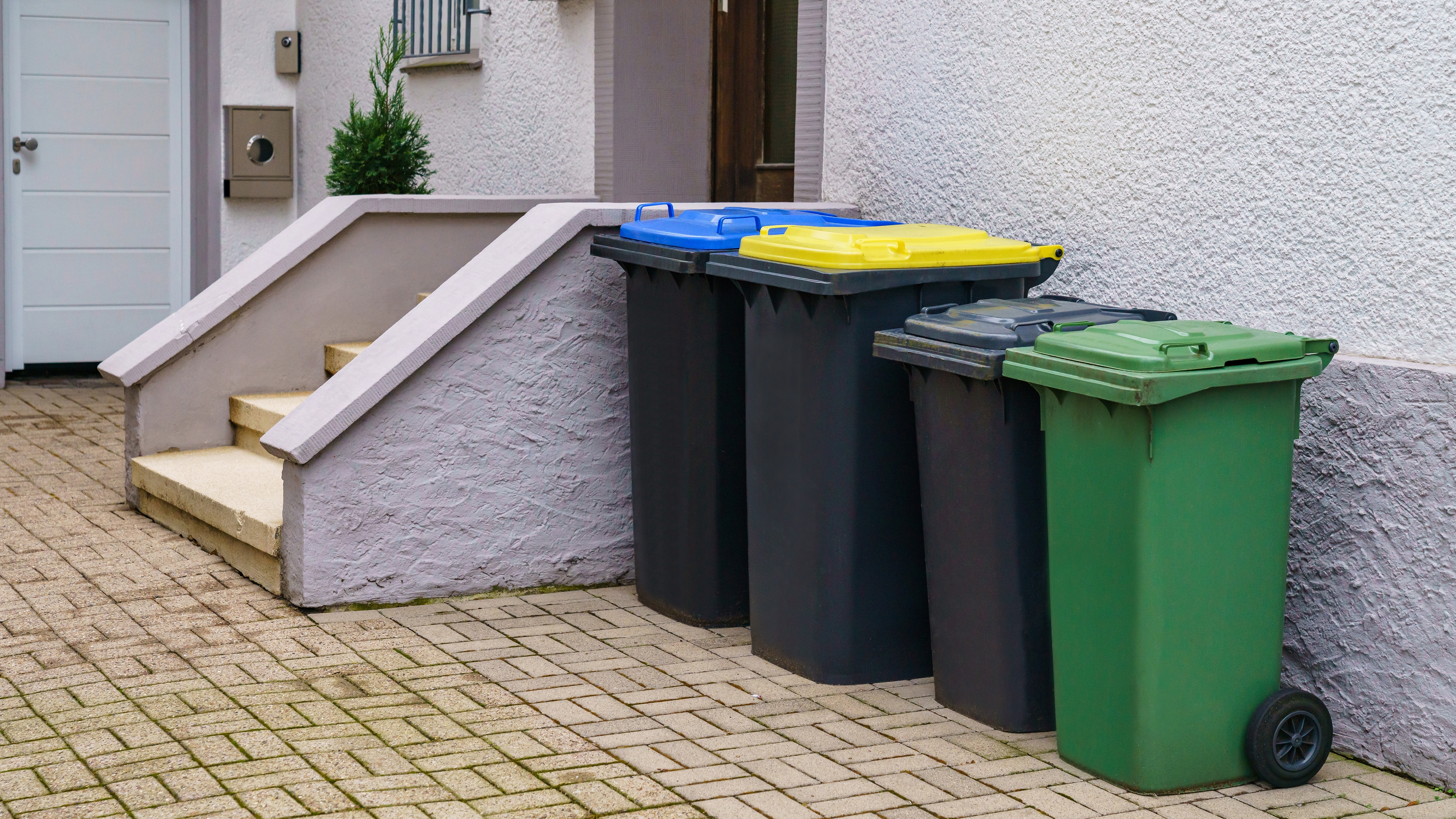 Row of garbage bins outdoors by house