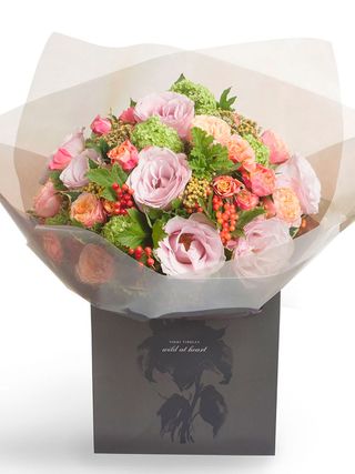 bouquet of flowers in wrapping and a gift bag